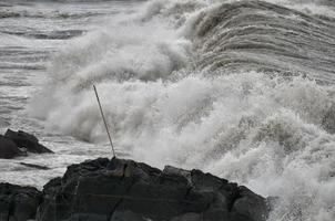 mar tempestade em a costa foto