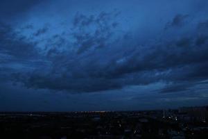 Sombrio azul nuvem com branco luz céu fundo e cidade luz meia noite tarde Tempo foto
