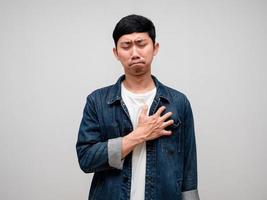 tristeza ásia homem jeans camisa sente desanimado, chorar, dor de cabeça isolado foto