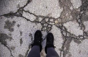 pés em rachado asfalto foto
