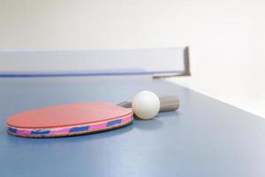 raquetes de ping pong e bolas na mesa foto