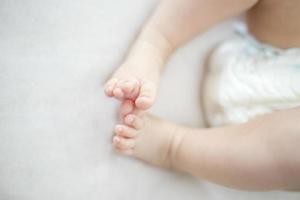 pés pequenos de menina na cama foto