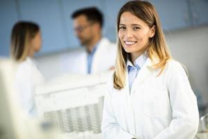 cientista com jaleco branco em pé no laboratório biomédico foto