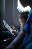 menino brincando com um tablet em um avião foto