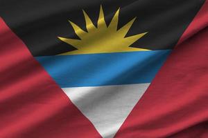 bandeira de antígua e barbuda com grandes dobras acenando de perto sob a luz do estúdio dentro de casa. os símbolos oficiais e cores no banner foto