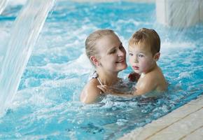 mãe e filho em uma piscina foto