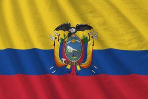 bandeira do equador com grandes dobras acenando de perto sob a luz do estúdio dentro de casa. os símbolos oficiais e cores no banner foto