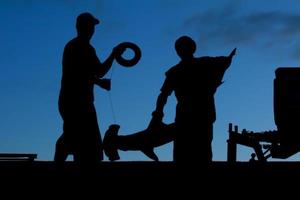 dois polinésio pescador a partir de tonga antes nascer do sol dentro uma silhueta com a cabeça de martelo Tubarão foto