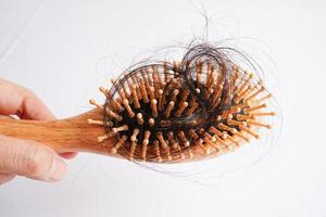 mulher asiática tem problema com perda de cabelo comprido anexar a escova de pente. foto