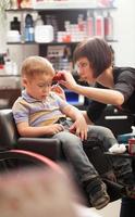 menino cortando o cabelo em um salão de beleza