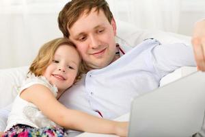feliz pai e filha com laptop