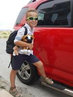 menino com um cachorro de pelúcia com um veículo foto