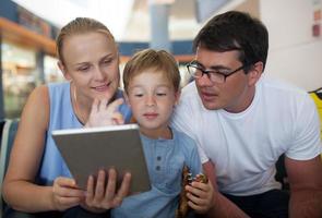 pais e filho com tablet no aeroporto foto