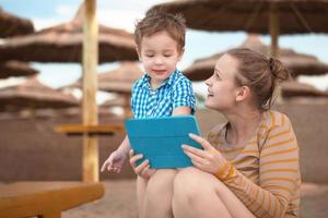 menino e mãe usando um tablet foto