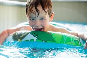 menino com uma boia em uma piscina foto