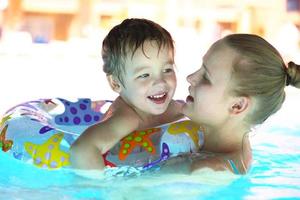 mãe e filho em uma piscina ao ar livre foto