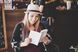 Mulher de negócios feliz lendo um livro enquanto relaxa no café foto