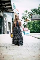 retrato de uma jovem mulher feliz com sacolas de compras, andando na rua