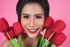 retrato de uma linda mulher com um buquê de flores de tulipa vermelha foto