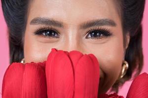 retrato de uma linda mulher com um buquê de flores de tulipa vermelha foto