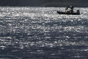 pescaria barco silhueta às pôr do sol dentro alassio Itália foto