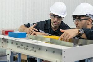 dois diverso profissional pesado indústria engenheiros vestindo segurança uniforme e Difícil chapéus trabalhando indústria e Engenharia pessoas tecnologia conceito . foto