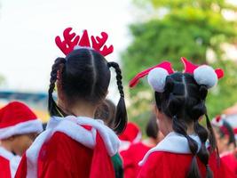 garotas com fantasia de tema vermelho na festa de natal da escola primária foto