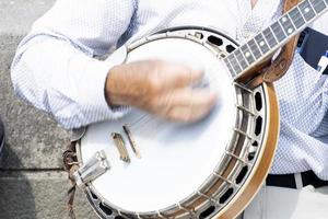 artista de rua tocando banjo músico detalhe das mãos foto