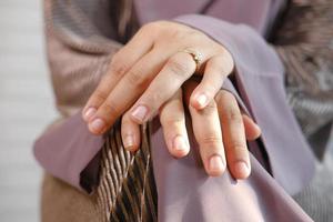 close-up das mãos de uma mulher com aliança de casamento foto