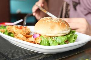 hambúrguer de carne e frango no prato em close-up de mesa de café foto