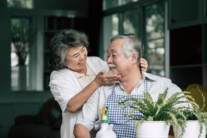 casal de idosos conversando e plantando árvores em vasos foto