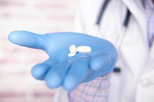 close-up de comprimidos brancos nas mãos do médico foto