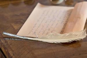 pluma e carta escrita à mão foto