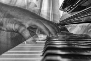 mãos jogando piano enquanto comovente dentro Preto e branco foto