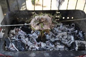 porco assado cozinhando no carvão na churrasqueira foto