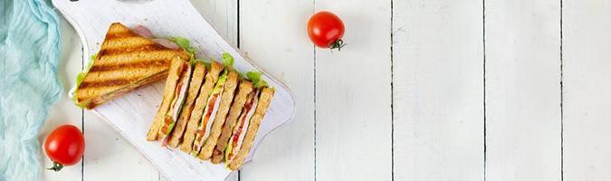 clube sanduíche com presunto, tomate, verde e queijo. grelhado panini. topo Visão foto