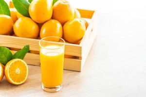 suco de laranja fresco e laranjas foto