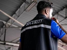 homem traseiro pessoa vestem camisa segurança conversa falar comunicação discussão talkie walkie rádio escolta segurança proteção masculino uniforme vigilância polícia ao controle Perigo ocupação trabalhos salvaguarda foto