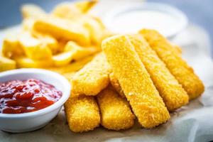 dedo de peixe e batatas fritas com ketchup de tomate e molho de maionese foto