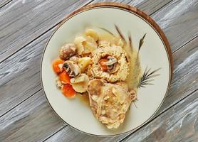 frango assado com cebola e cogumelos no prato com arroz e cenoura. cozinha gourmet francesa foto