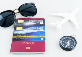 passaportes e cartões de crédito, óculos de sol, avião em branco foto