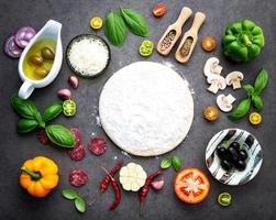 massa de pizza e ingredientes frescos foto