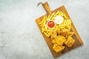 asas de frango com batata frita, ketchup e maionese foto