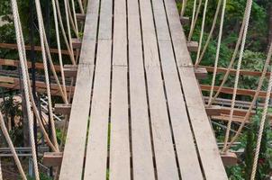 ponte pênsil, passagem para os aventureiros, atravesse para o outro lado da floresta foto