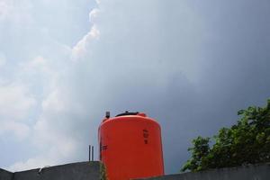 grande laranja água reservatório em a cobertura do a casa. foto