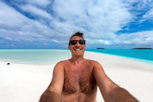 selfie do feliz homem em tropical polinésio de praia foto