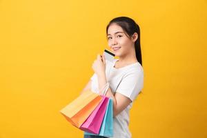 mulher segurando sacolas coloridas e cartão de crédito foto