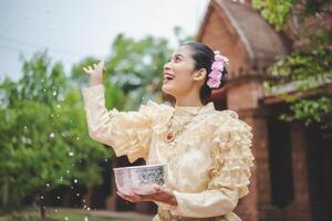 retrato mulher bonita no festival songkran com traje tradicional tailandês foto