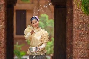 retrato mulher bonita no festival songkran com traje tradicional tailandês foto