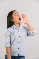 retrato de uma jovem mulher asiática gritando história ou fazendo anúncio sobre fundo branco isolado foto